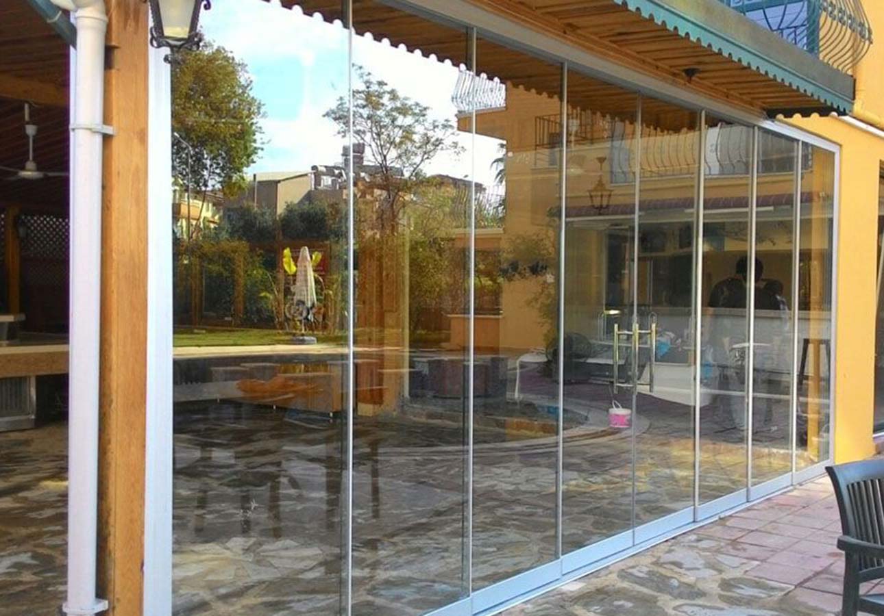Frameless sliding glass panels open to the garden