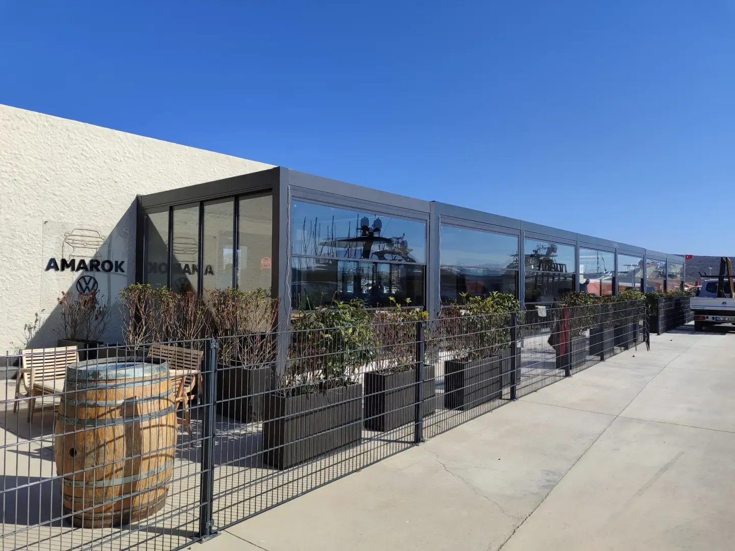 Café terrace enclosed with glass under a bioclimatic pergola
