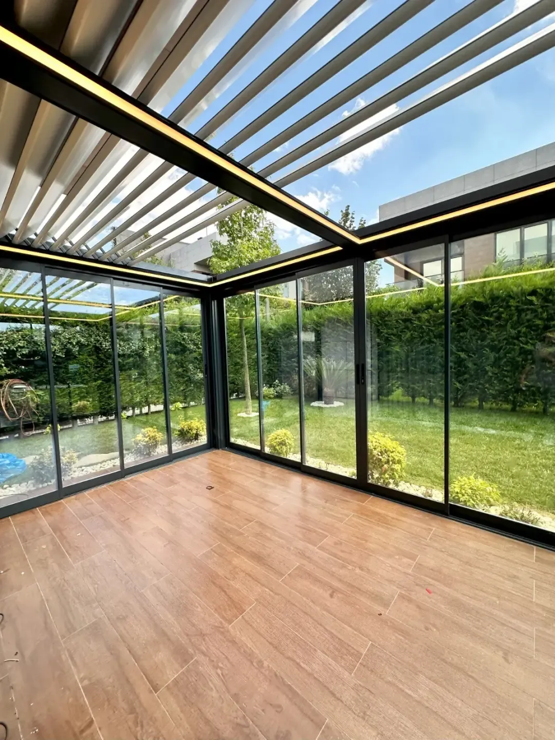 Bioclimatic pergola enclosed with sliding glass walls
