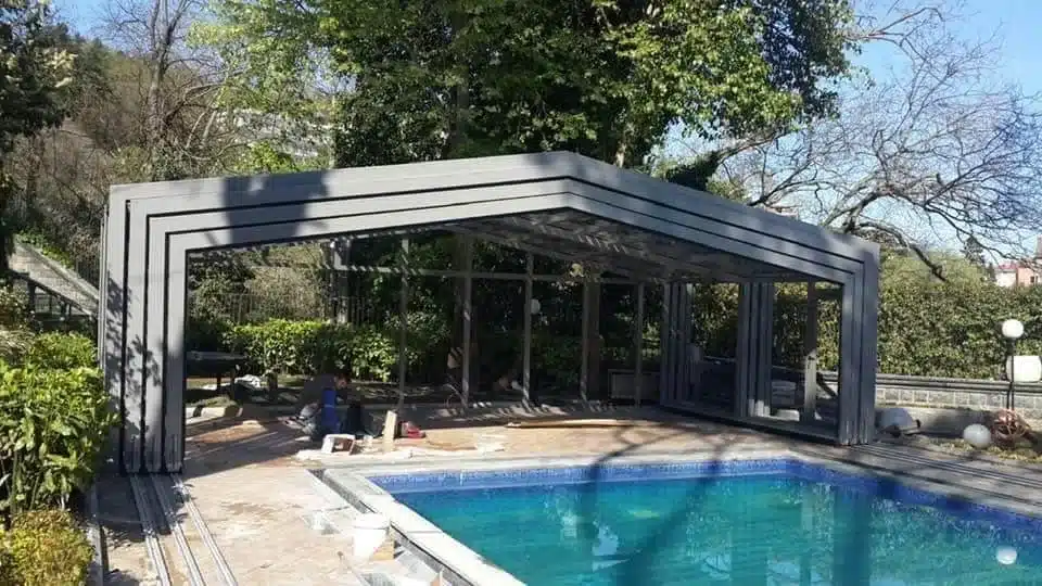 Retractable glass roof enclosing a swimming pool