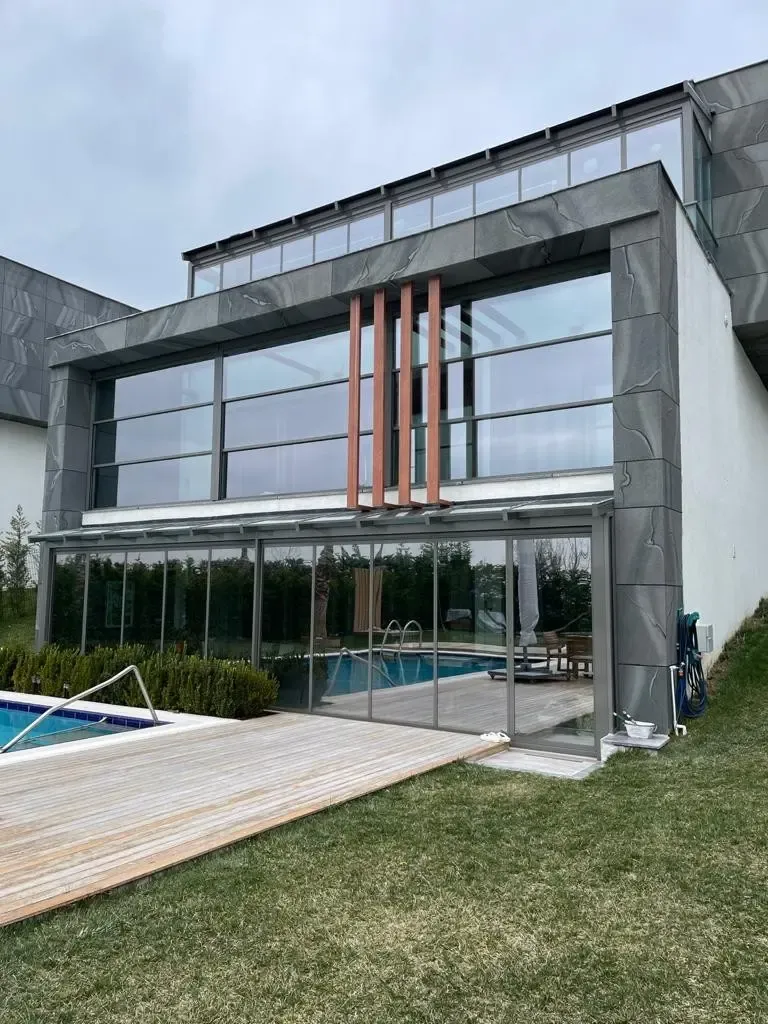 Garden pool house enclosed with guillotine glass