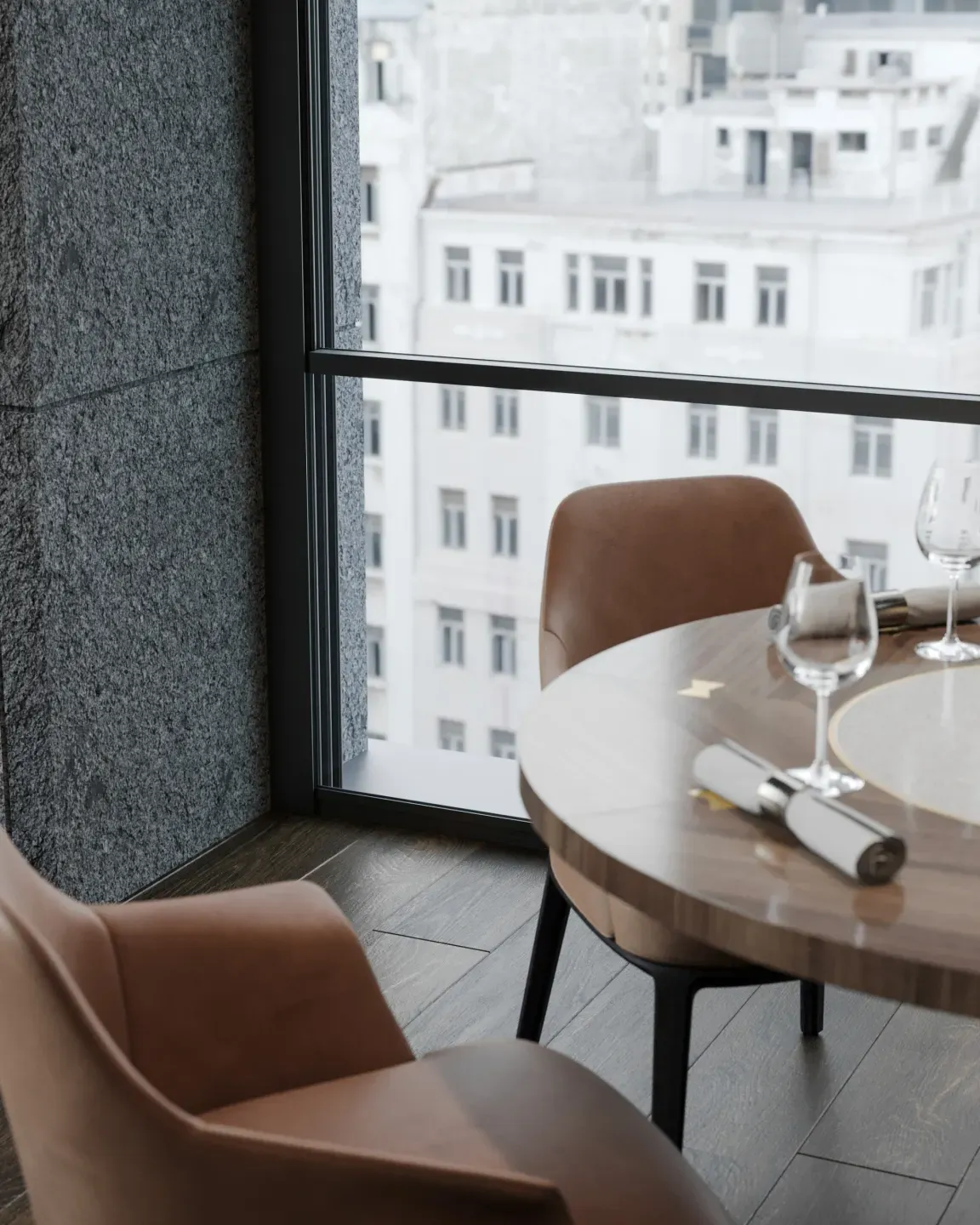 Table beside guillotine glazing with a city view