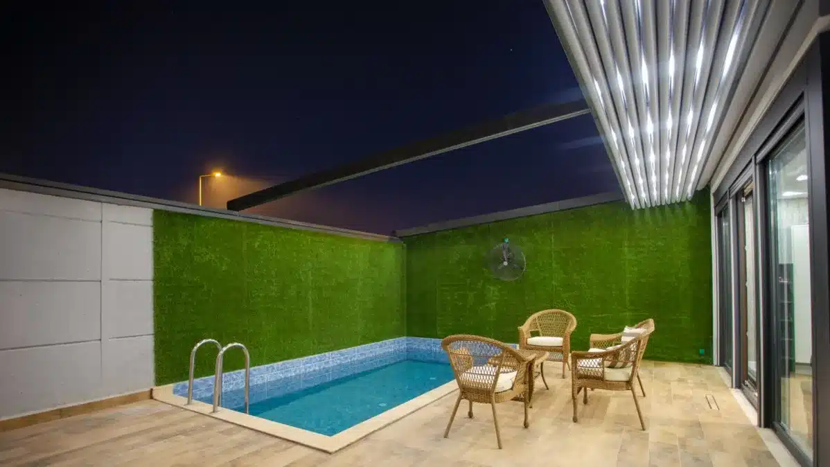 Retractable awning pergola with LED lighting by a pool