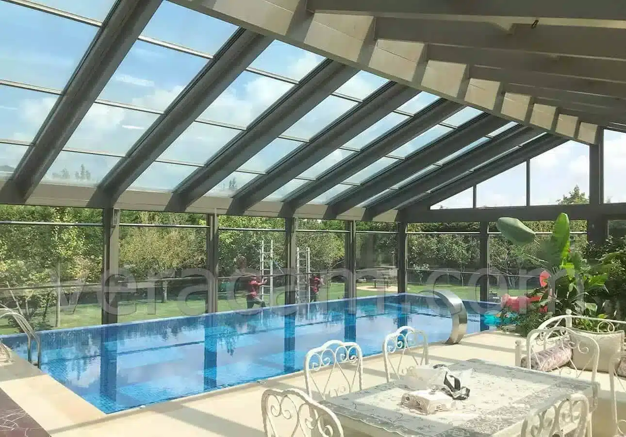 Retractable glass roof enclosing a swimming pool